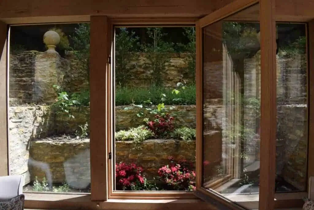 Oak framed garden room design connecting indoor living space with a landscaped garden